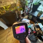 Infrared camera showing thermal readings during an on-site water-damage inspection.